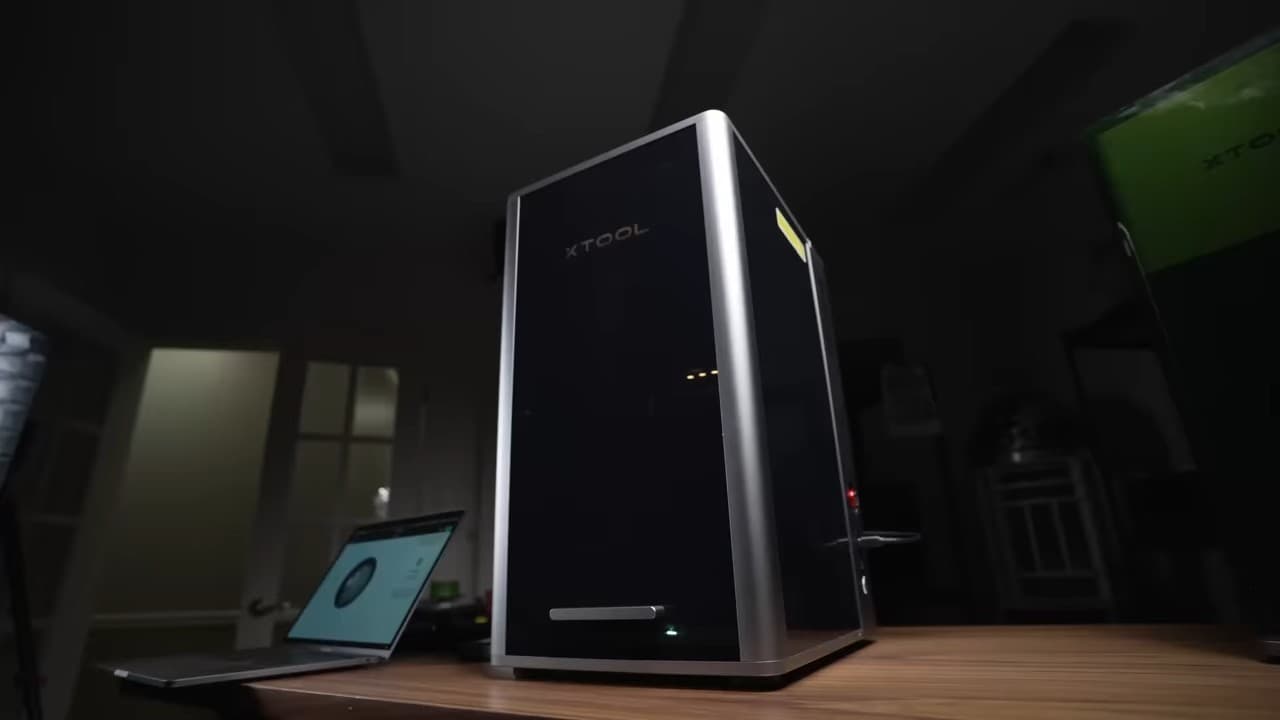 Hand demonstrating gesture control feature on xTool F2 Ultra 60W MOPA fiber laser engraver with dual camera system and motorized bed